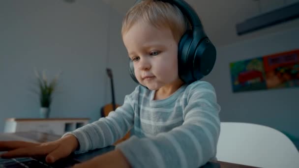 Niño Pequeño Activo Escucha Música Los Auriculares Que Escriben Ordenador — Vídeos de Stock