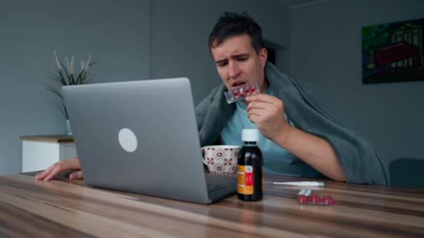 Chory Człowiek Sprawdza Instrukcję Dla Pigułek Internecie Pomocą Laptopa Siedzącego — Wideo stockowe
