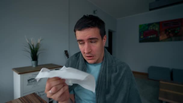 绝望的人拿一卷白餐巾擦拭流鼻涕 染病的男子裹着毛毯在家里近距离处理流感 — 图库视频影像