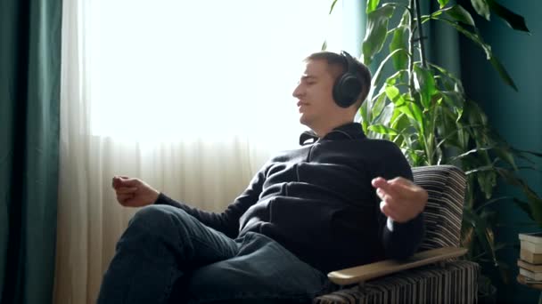 Side Visning Unge Mand Afslappet Tøj Sidder Sofaen Lytte Til – Stock-video
