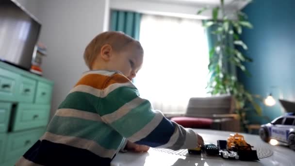 Günlük Kıyafetlerle Gezen Çocuk Rahat Dairelerde Kameraya Bakarak Araba Oyuncaklarıyla — Stok video