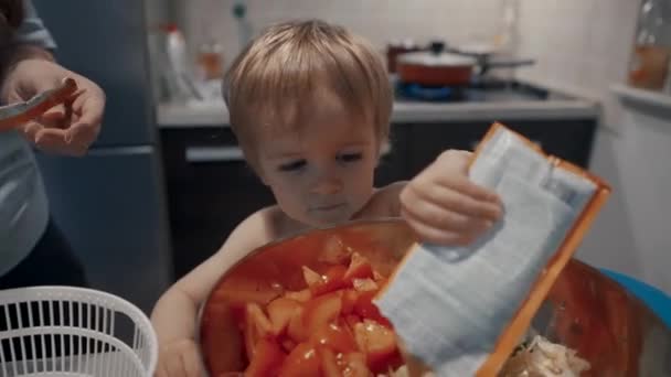 Ein Kleiner Junge Steht Vor Einer Schüssel Mit Lebensmitteln Und — Stockvideo