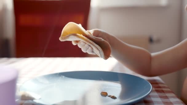 Küçük Bir Çocuk Bir Masada Oturup Bir Parça Yemeğin Tadını — Stok video