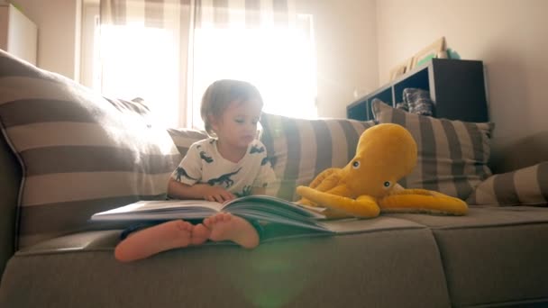 Malý Chlapec Sedí Gauči Útulném Obývacím Pokoji Čte Knihu Cvičí — Stock video