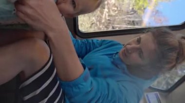 Annem, İsviçre dağlarına giderken trende ayakta durmayı öğrenen küçük kızın elini tutuyor. Mutlu kadın ve tatlı bebek tatilin tadını çıkarın. Yakın çekim dikey çekim..