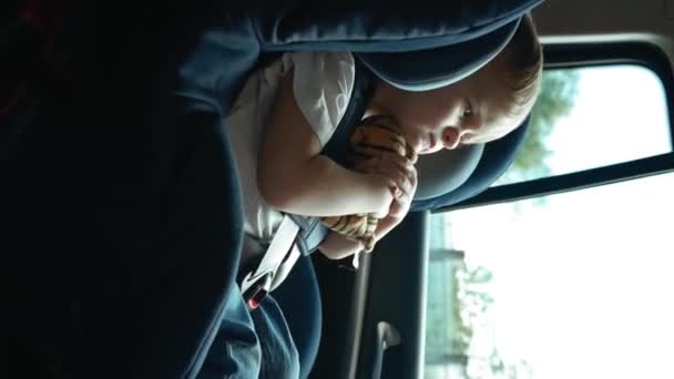 車の座席に安全に座っている少年を撮影したビデオです バーティカル映像 — ストック動画