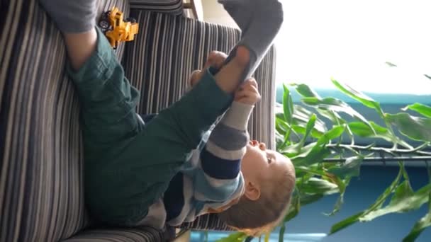 Bambino Seduto Una Poltrona Nel Salotto Accogliente Cercando Mettere Calzino — Video Stock