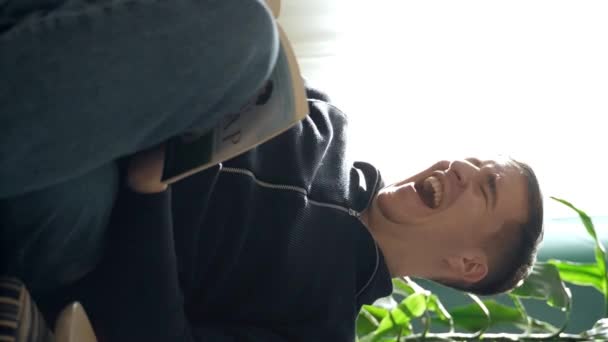 Радісне Читання Людина Кріслі Сміється Радістю Занурюється Книгу Сцена Випромінює — стокове відео