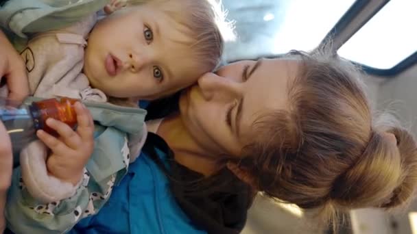 Mãe Amorosa Beija Filha Sentada Perto Janela Com Luz Solar — Vídeo de Stock