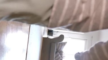 Bu büyüleyici videoda, meraklı küçük bir çocuk oturma odasının harikalarını keşfediyor, her köşede büyüyü keşfediyor. Dikey görüntüler.