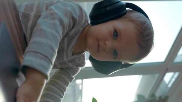 Kulaklıklı Şirin Çocuk Masada Oturan Dizüstü Bilgisayarın Klavyesini Tutuyor Yürüyen — Stok video