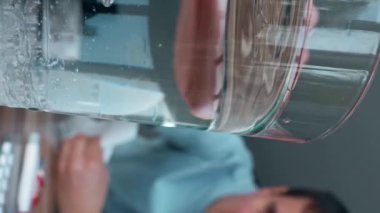 Hasta adam hapları bardağa su ile atar. Burnunu peçeteyle siler. Erkek kişi doktorların tavsiyelerine uyuyor. Yavaş çekimde, dikey görüntülerde..