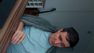 Ekoseyle kaplanmış hasta serbest çalışan evde oturan dizüstü bilgisayarla çalışmaya çalışıyor. Adam hapşırdığı ve peçetelerle burnunu sildiği için kötü hissediyor..