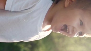 Çimlerin üzerinde duran genç bir çocuğu gösteren bir video. Dikey görüntüler.