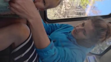 Annem, İsviçre dağlarına giderken trende ayakta durmayı öğrenen küçük kızın elini tutuyor. Mutlu kadın ve tatlı bebek tatilin tadını çıkarın. Yakın çekim dikey çekim..