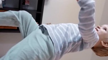 Çevrelerinden büyülenmiş küçük bir çocuk, merak ve merakla dolu lüks bir kanepede oturur ve her gün saklı olan büyüyü keşfeder. Dikey görüntüler.