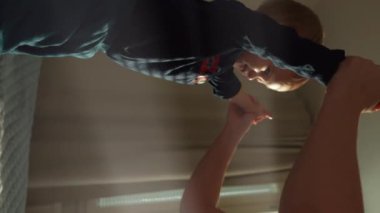 Neşeli çocuk, sabahın erken saatlerinde annenin elini tutuyor. Kadın hafta sonu şirin bir çocuğu ağırlıyor. Yavaş çekimde, dikey çekimde..