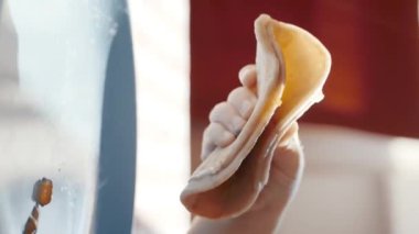 Küçük bir çocuk bir masada otururken, bir parça yemeğin tadını çıkarırken görülebilir. Dikey görüntüler.