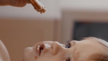 Küçük bir çocuğu yemek yerken görüntüleyen bir video. Dikey görüntüler.