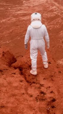 Tanınmayan astronot el sallayarak Mars 'ta yardım istiyor. Beyaz ekipman ve kaskı koruyan profesyonel kozmonot dikkatleri üzerine çekiyor. Dikey Çekim.