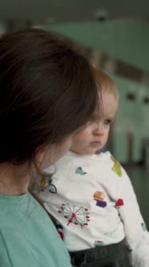 Bir buçuk yaşındaki bir çocuk parmağını camdan dışarı, annesinin yanına doğru tutar. Genç bir anne uçuştan önce oğluna yeni kelimeler öğretir..