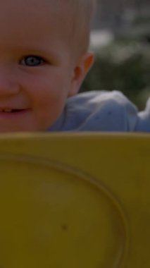 Genç bir çocuk güneşli sarı bir salıncakta mutlu bir şekilde oturuyor, gök kubbenin altında neşeyle gülümserken neşe ve memnuniyet saçıyor.