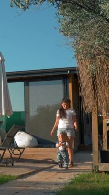 Anne ve oğlu büyük modern kır evine giden dar bir yolda yürüyorlar. Kadın ve küçük çocuk hafta sonunu yüzme havuzunda geçirdiler..