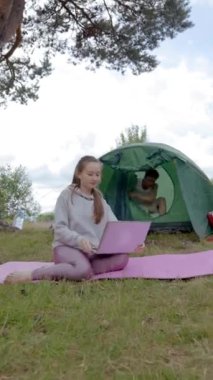 Genç bir kadın sosyal medyada ilginç bir sahne buluyor ve heyecanlı erkek arkadaşını dizüstü bilgisayarında gösteriyor. Birkaç mutlu turist video izleyip çimlerin üzerinde dikey oturarak tartışır..