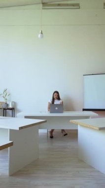 Çevrimdışı. Kadın masada dizüstü bilgisayarın yanına oturmuş konferansa hazırlanıyor. Masalarda dikey çekim yapan genç erkek ve kadınlara geçiş formu.