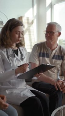 Doktor oturma odasında yaşlı bir çiftle oturup sağlık sorunlarını tartışıyor. Kadın uzman, kıdemli erkek ve kadınla konuşuyor. Tedavi planını dikey olarak yazıyor..