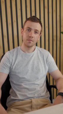 Çevrimiçi konferansta video aracılığıyla çalışan genç iş adamlarının POV 'u. Adam ofisinde oturmuş kameraya bakıyor ve başını dikey olarak sallıyor..