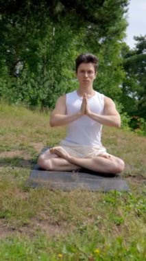 Lotus 'ta oturan adamdan yeşil çimenli çayırda poz verirken stüdyoda öğrencilerle meditasyon yaparken. İnsanlar yoga ve dikey çekim yapmayı seviyor..