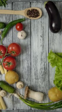 Ahşap mutfak tezgahına atılmış beyaz boş bir sayfa ve sebzeli kaşık ve baharatlı yemek kitabının en üst görüntüsü. Makbuzunu boş bir kağıda koymak kolay. Dikey çekim.