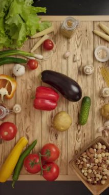 Aynı anda hem biber, hem patlıcan, hem salatalık, hem de ahşap kırsal masadan patates alan insanların dikey çekim için gerekli malzemelerle dolu bir fotoğrafı..