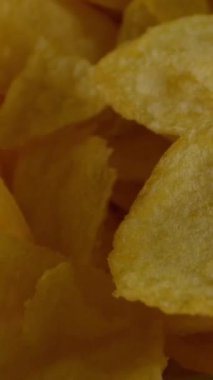 Yukarıdaki kameradan, içi tuzlu patates cipsi dolu kasenin üzerinden geçiyor. Dikey çekim.