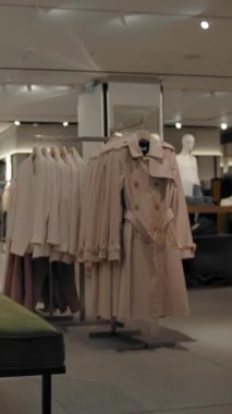 Kıyafet seçen iki kadın müşterinin olduğu boş kıyafet mağazasının zaman aşımı. Kamera oyuncağı hareketi. Az müşterisi olan modaya uygun bir perakende. Hızlı hareket. Dikey çekim.