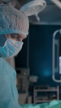 Ameliyathanede karar vermeden önce birbirine bakan iki ciddi doktor. Deneyimli cerrah, genç kadın ve yetişkin beyaz erkek hastalığın tedavi yolunu belirledi.