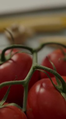 Boş not defteriyle kereste masasında ilerleyen kamera ve mutfakta spagetti hazırlamak için ham malzemeler. Dikey çekim.