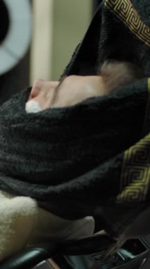 Kadın berber müşterileri sıcak havluya sarar. Müşteriyi berber dükkanında traş olmaya hazırlıyorum. Başarılı küçük işletme konsepti. Ağır çekim. Dikey çekim.