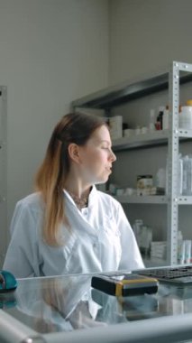 Eczanedeki kadın eczacıdan beyaz paketle sipariş alıyor. Yetişkin bir adam ilaçlarını almak için geldi ve parasını kredi kartıyla ödedi. Dikey çekim.