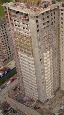 Vinç ve kirişlerin havadan çekilmiş görüntüleri, yeni modern bina inşaatçıları ve teknik olarak çok katlı düz evin yüksekliği. Dikey çekim.