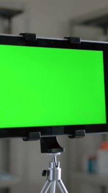 Dolly, eczanenin içinde içi ilaçlarla dolu dijital bloknotların yakın çekim yeşil ekran görüntüsüyle. İçeriğiniz için tablet bilgisayardaki görüntüyü takip edin ve değiştirin. Dikey çekim.