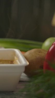 Mutfaktaki ucuz Çin erişteleri, çeşitli otlar ve sebzelerle dolu konteynıra yakınlaştıran kamera. Vejetaryen yemeği ve yeşillik konsepti. Dikey çekim.