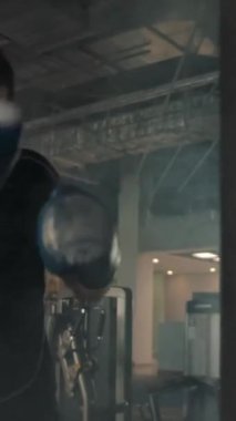 Modern bir spor salonunda yumruk torbası takan beyaz bir sporcunun yan görüntüsü. Gerçek zamanlı ve ağır çekimde. Dikey çekim.