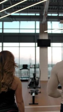 İki sporcunun beşliği ağır çekimde antrenmana gidiyor. Spor dayanıklılığı uzmanları boş bir modern spor salonunda antrenmana hazırlanıyorlar. Destansı bir çekim. Dikey çekim.