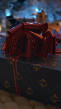Mavi Noel hediye kutusundan kırmızı pruvayla Xmas ağaç tepesine doğru Dolly dikey çekim. Yeni yıl hediyesi beklentisi konsepti. Dikey çekim.