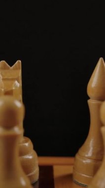 Dama tahtasında beyaz, ahşap, otantik satranç. Dolly kaydırma hareketi yakın plan. Eski satranç konseptindeki iş stratejisi. Dikey çekim.