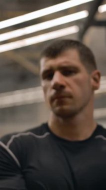 Spor salonundaki profesyonel sporcunun yüzünden Dolly vuruldu. Ciddi yüz ifadesi olan bir sporcunun yüzüne çarpan destansı kamera. Yavaş çekim dikey çekim.