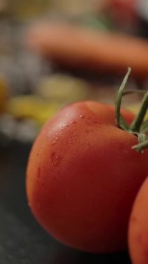Yakın plan kamera solda olgun domates ve biberi gösteriyor. Mantar ve mutfaktaki farfalle makarna masasının yanına yerleştiriliyor. Tuz ve diğer baharatlar. Vejetaryen makarna hazırlığı. Dikey çekim.