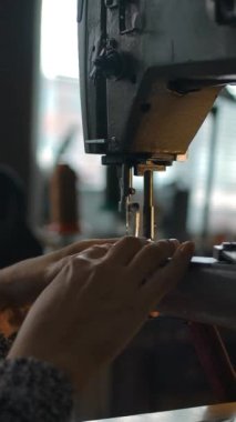 Terzi kadın dikiş makinesi, tekstil ve kumaş dikiyor. Dikiş atölyesi geçmişi. Atölye, tamirat ve terzilik konsepti. El işi üretimi. Kameralar dikey görüntüyü gerer.